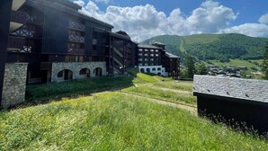 Un edificio de varios pisos, con muros de piedra y una combinación de estilos arquitectónicos modernos y tradicionales.