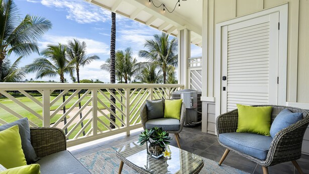 A covered porch with wicker furniture, a glass coffee table, and a view of palm trees and a lawn. - 🏖️Waikoloa Penthouse w/ Golf & Lake Views | Walk to A-Bay | Fairway Villas J34 (Waikoloa)