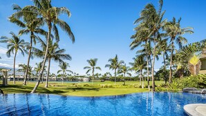 A clear blue pool surrounded by palm trees and a well-maintained lawn. - 🏖️Waikoloa Penthouse w/ Golf & Lake Views | Walk to A-Bay | Fairway Villas J34 (Waikoloa)