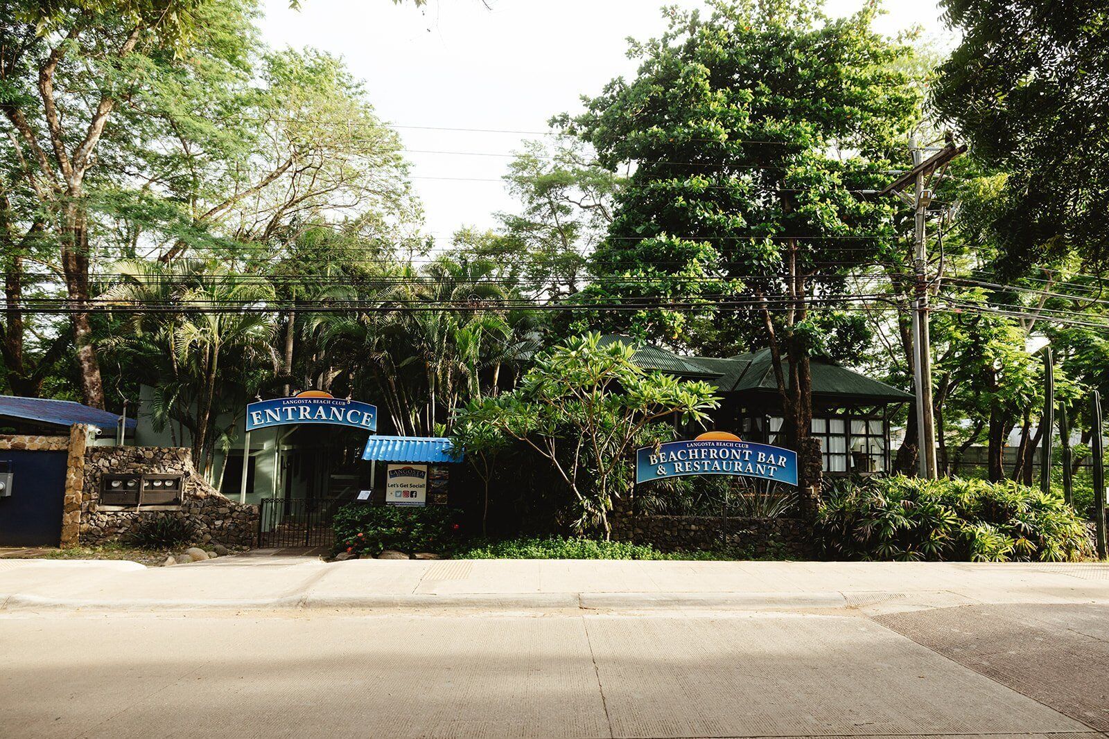 The entrance to Langosta Beach Club with a sign for the Beachfront Bar & Restaurant.