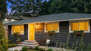 A single-story house with a front porch, a bench, and a mailbox.