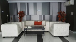 A modern living room with a sectional sofa, a coffee table, and decorative plants.
