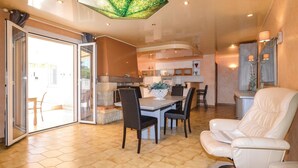 A spacious living area with a dining table, comfortable seating, and a view through a glass door to an outdoor patio. - Pet friendly home in Borgo (Borgo)