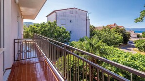 A balcony with a view of a white building, lush greenery, and a clear sky. - 2 bedroom awesome apartment in Crikvenica (Crikvenica)