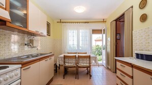 A compact kitchen with a dining area, a stove, and a sink. - 2 bedroom awesome apartment in Crikvenica (Crikvenica)