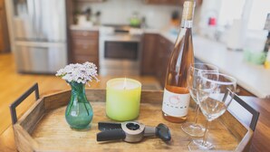 A wooden tray with a candle, a bottle of wine, a glass, and a bottle opener on a kitchen counter. - PUMA POINT...Overlooks the Alsea Bay...Has perfect ocean sunset views! Sleeps 3. (Waldport)