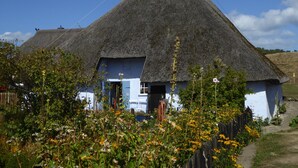 A traditional thatched-roof house with a blue exterior and a door. - 3 bedrooms to 6 people, Sauna, terrace, 4 * equipment, sea view (Sellin)