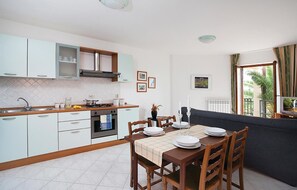 Enjoy meals in this well-equipped kitchen and dining area, featuring an oven and stainless steel range hood.