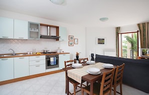 Enjoy meals in this well-equipped kitchen and dining area, featuring an oven and stainless steel range hood.