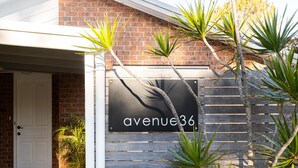 Un bâtiment avec une enseigne portant l’inscription « avenue36 », fixée sur un mur de briques.