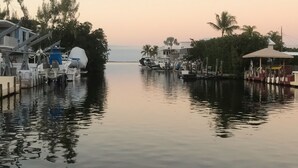 Un puerto deportivo con barcos amarrados, un área techada y un edificio con techo azul.