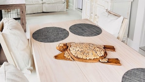 Una sala de estar moderna con techo de madera, muebles blancos y un espejo grande.