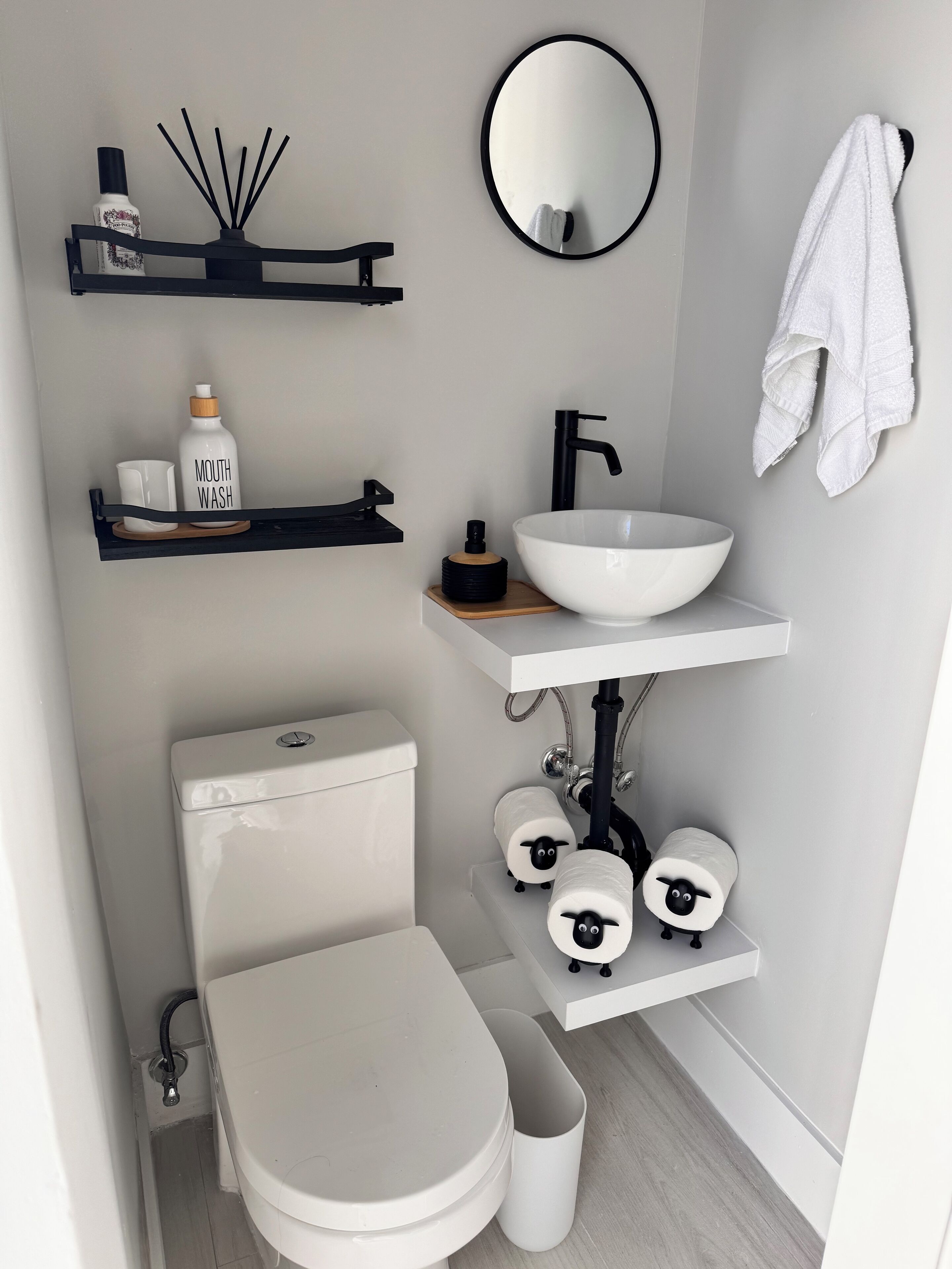 Ein modernes Badezimmer mit Toilette, Bidet, Waschbecken und Handtuchhalter.