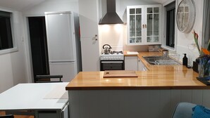 Une cuisine moderne dotée d’un îlot central, d’une cuisinière encastrée et d’un réfrigérateur.