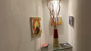 A glass display shelf with a vase and books, surrounded by white walls and artwork. - View of Castel Sant'Angelo (Roma)