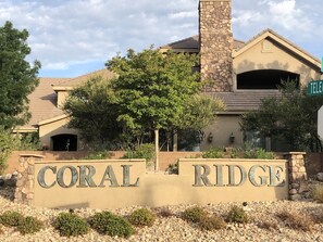 A residential building with a stone chimney, a large tree, and a sign that reads "CORAL RIDGE". - Your home away from home! (Washington)