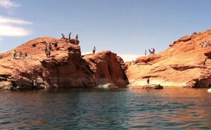 A rocky landscape with people standing on the cliffs and a body of water in the foreground. - Your home away from home! (Washington)