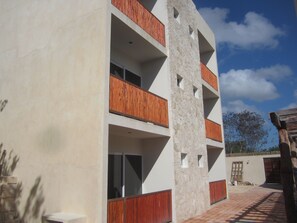 Stylish building with balconies and a central column, offering outdoor space for residents.