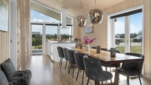A modern kitchen with a wooden ceiling, large windows, and a central island with chairs. - Gorgeous home in Væggerløse with WiFi (Væggerløse)