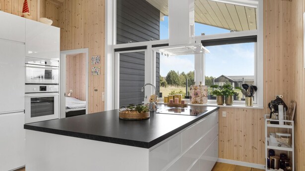 A modern kitchen with a large island, white cabinetry, and a view of the outdoors. - Gorgeous home in Væggerløse with WiFi (Væggerløse)