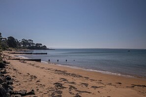 Walk along the beach on a wooden walkway, surrounded by the soothing sounds of the ocean.