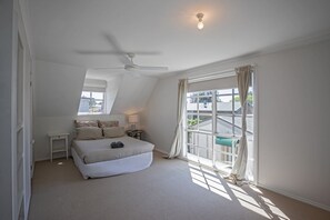 Relax in this cozy loft-style bedroom with a single bed, bedside table, and ceiling fan.