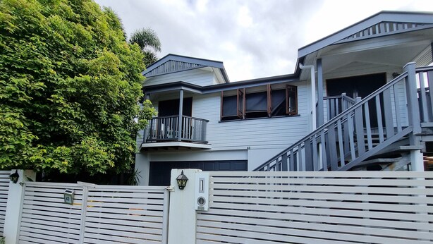 A two-story house with a balcony, a gated entrance, and a staircase leading to the upper floor. - Self Contained Studio - Air-conditioned WiFi (Parramatta Park)