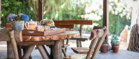 Une table en bois rustique, avec un seau en métal et une plante en pot.