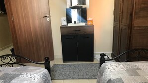 A bedroom with two beds, a small black cabinet, a mirror, and a door. - nice apartment in marrakech (Marrakech)