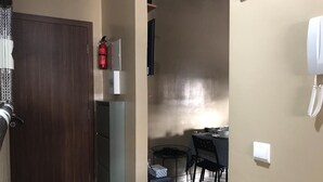 A compact living space with a kitchenette, a dining area, and a phone on the wall. - nice apartment in marrakech (Marrakech)