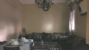 A dining area with a table set for four, a sofa, and a chandelier. - nice apartment in marrakech (Marrakech)