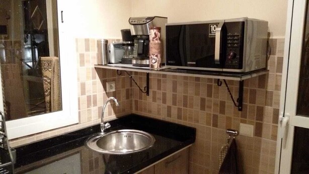 A compact kitchen with a sink, a coffee maker, a microwave, and a toaster. - nice apartment in marrakech (Marrakech)