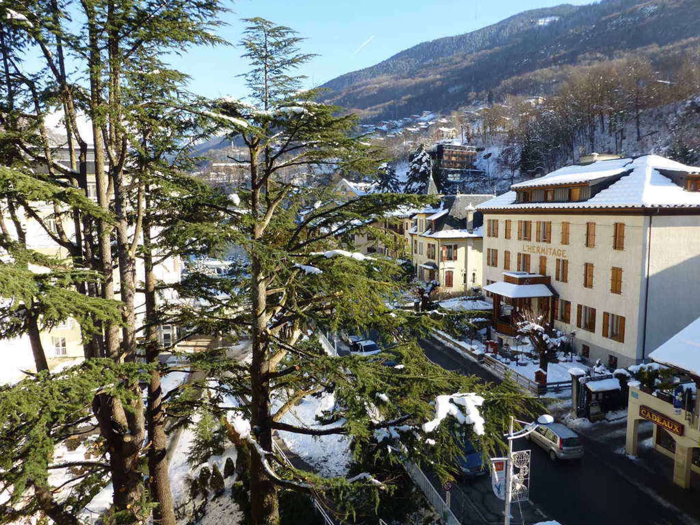Une ville enneigée, avec des bâtiments et des arbres recouverts de neige.