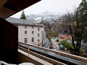 A view from a balcony overlooking a building with multiple windows and a mountain in the background. - Studio 2 Pers. City Center with Balcony (Brides-les-Bains)