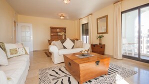 A living room with a white sofa, a wooden coffee table, and a leopard print rug. - Marina de la Duquesa 241 (Manilva)