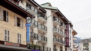 A multi-story building with balconies, a pub sign, and a restaurant sign.