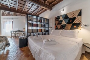 A bedroom with a large bed, a bookshelf, and a geometric wall art piece. - Great apartment - Navona area (Roma)