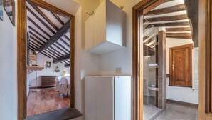 Un couloir étroit avec un plafond en bois et un meuble blanc.