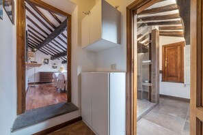 A narrow hallway with a wooden ceiling and a white cabinet.