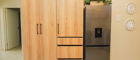 Una cocina con un armario de madera y un refrigerador de acero inoxidable.