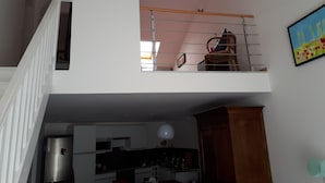 Um apartamento de dois andares, com cozinha no andar térreo e varanda no andar superior.