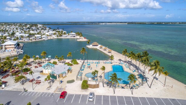 A coastal resort with a swimming pool, beach area, and a view of the ocean.