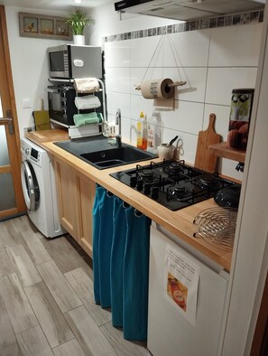 Une cuisine équipée d’un lave-linge, d’une cuisinière et d’un four à micro-ondes.