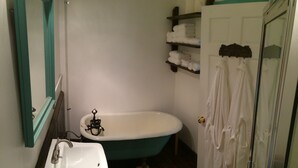 A bathroom with a white sink, a freestanding bathtub, and a glass shower enclosure.