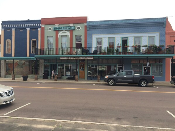 A street view with a row of buildings, including a furniture store named 'The Furniture Store'.
