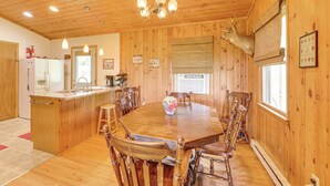 A wooden interior with a dining table, chairs, a chandelier, and a mounted deer head. - Fish, Hike, Hunt: Secluded Cabin in Doe Hill! (Doe Hill)