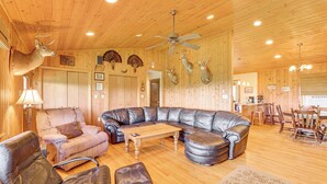 A spacious living room with a large leather sectional sofa, a wooden coffee table, and leather armchairs. - Fish, Hike, Hunt: Secluded Cabin in Doe Hill! (Doe Hill)