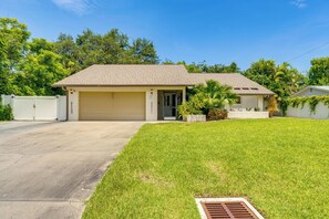 A single-story house with a garage, a well-maintained lawn, and a clear sky. - Pet-Friendly Home w/ Pool, Close to Venice Beaches (Venice)