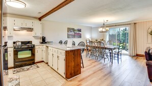 A spacious kitchen with a central island, wooden cabinets, and a large window providing natural light. - Newly Renovated Sky Valley Condo w/ Mtn Views (Sky Valley)