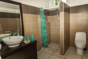 Regadera, secadora de cabello, toallas, papel de baño 